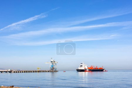 Photo for Liquefied petroleum gas tanker and tugboats. The ships, basically oil tankers, had been converted by fitting small, riveted, pressure vessels for the carriage of LPG into cargo tank spaces. - Royalty Free Image