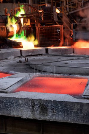Téléchargez les photos : View of the copper casting to the molds in the smelting of the industrial plant. Smelting is a process of applying heat to ore in order to extract a base metal. - en image libre de droit