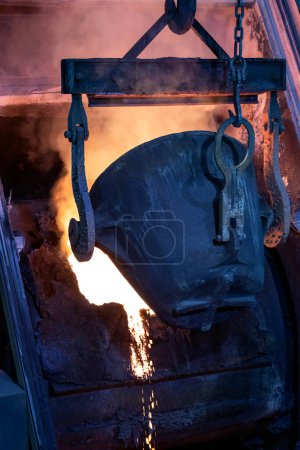 Foto de Molten copper is pouring to melting pot. Combining copper with tin and/or arsenic in the right proportions produces bronze, an alloy that is significantly harder than copper. - Imagen libre de derechos