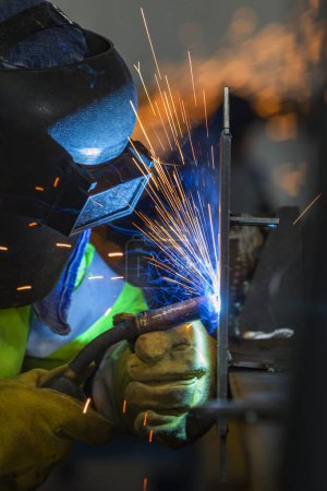 Téléchargez les photos : Le soudeur soude un acier de construction avec soudure à l'arc métallique au gaz (GMAW) dans l'atelier. - en image libre de droit