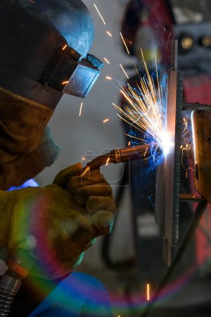 Photo for The welder is welding a structural steel with gas metal arc welding ( GMAW ) in the workshop. - Royalty Free Image