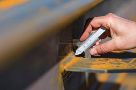 Téléchargez les photos : L'inspecteur mesure l'épaisseur des soudures d'angle avec étrier de soudage (jauge). - en image libre de droit