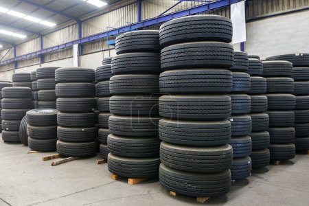 Photo for View of assorted new automotive road tires or tyres, showing a variety of tread patterns. It is a ring-shaped component that surrounds a wheel's rim to transfer a vehicle's load. - Royalty Free Image