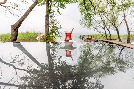 Foto de Paisaje del lago Sapanca y té turco sobre la mesa. El lago Sapanca (en turco: Sapanca Golu) es un lago de agua dulce en Turquía, entre el Golfo de Zmit y el prado de Adapazari.. - Imagen libre de derechos