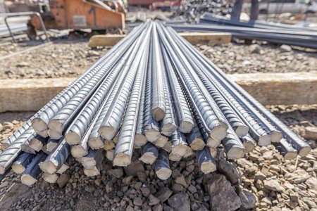 Photo for View of the rebar. Rebar's surface is often deformed to promote a better bond with the concrete. The most common type of rebar is carbon steel, typically consisting of hot-rolled round bars with deformation patterns. - Royalty Free Image
