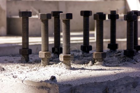Photo for View of the anchor bolts for fondation in the concrete. An anchor bolt is a fastener used to attach objects or structures to concrete. There are many types of anchor bolts. - Royalty Free Image