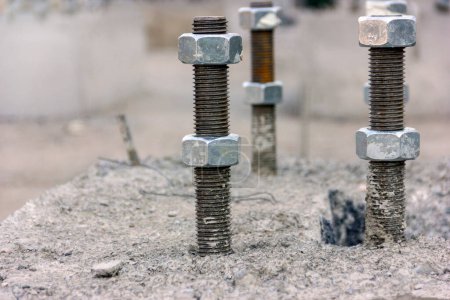 Photo for View of the the anchor bolts and nuts in the concrete foundation in the new industrial plant. - Royalty Free Image