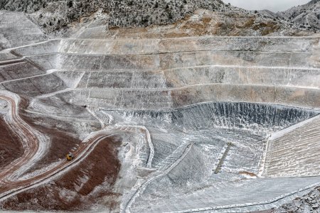 Photo for New industrial mine waste dam (tailing dam) with snowy weather. Tailings dams rank among the largest engineered structures on earth. Open pit mine. - Royalty Free Image