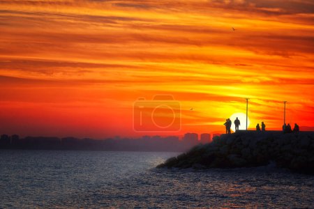Téléchargez les photos : Coucher de soleil sur la ville de Mersin. Mersin est une grande ville qui s'étend le long de la côte, elle a le plus long littoral de Turquie ainsi que dans la Méditerranée orientale. - en image libre de droit