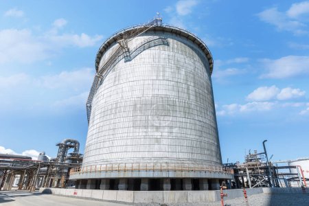 Double wall, cylindrical and vertical ammoniac storage tank in the factory. Ammonia is used in numerous different industrial application requiring carbon storage vessels. The refinery plant for storage