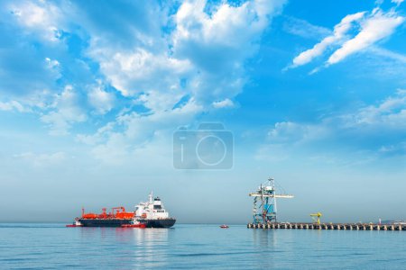 Foto de Pilotos marítimos atracan buque lpg en el muelle del puerto. Un portador de gas, un tanque de gas, un portador de GLP o un tanque de GLP. el barco está amarrado en el mar contra el cielo azul. - Imagen libre de derechos