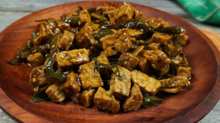 Orek tempe oder Sauteed Tempe ist eine typisch indonesische Küche mit Kräutern, Knoblauch, Zwiebeln, Chili, langen Bohnen und Sojasauce. Es schmeckt köstlich. isoliert auf grauem Hintergrund