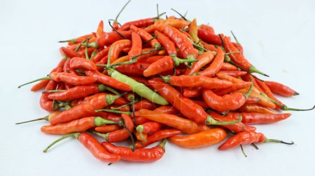 Foto de Gran pila de chiles chiili en diferentes colores, amarillos, verdes y rojos, aislados en blanco; también conocidos como chiles, chiles o simplemente chile - Imagen libre de derechos