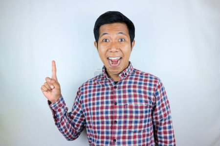 Hombre asiático sonriendo mientras apunta hacia arriba presentando el producto. concepto publicitario