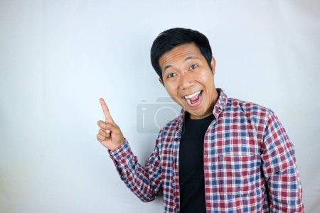Hombre asiático expresión sonriendo mientras señala al lado presentando el producto. concepto publicitario