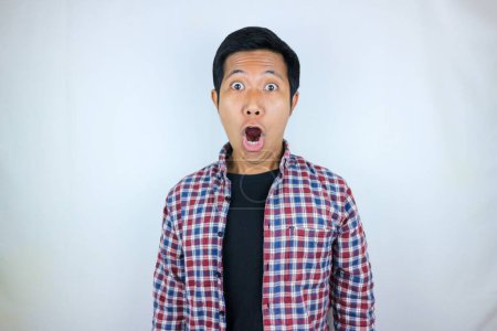 funny expression of shocked and surprised Asian man in flannel shirt isolated on white background