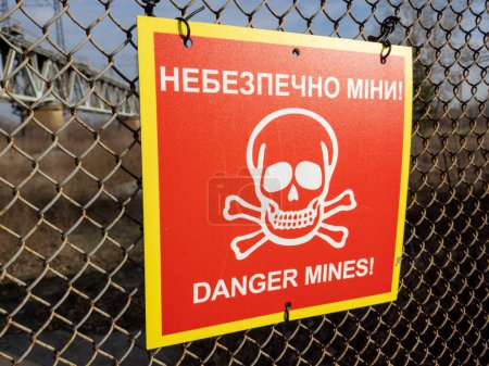 Red sign 'Danger mines' with skull and bones on rabitz wall in Kyiv