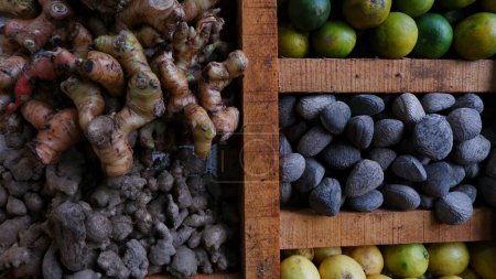 Foto de Limón, jengibre, cúrcuma y otras especias se muestran y comercializan en mesas de madera divididas en el mercado tradicional. para el condimento y la salud (hierbas). - Imagen libre de derechos
