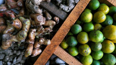 Foto de Limón, jengibre, cúrcuma y otras especias se muestran y comercializan en mesas de madera divididas en el mercado tradicional. para el condimento y la salud (hierbas). - Imagen libre de derechos