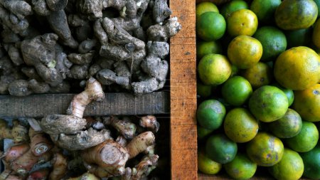 Foto de Limón, jengibre, cúrcuma y otras especias se venden en una mesa particionada de madera en el mercado tradicional. para el condimento y la salud (hierbas). - Imagen libre de derechos