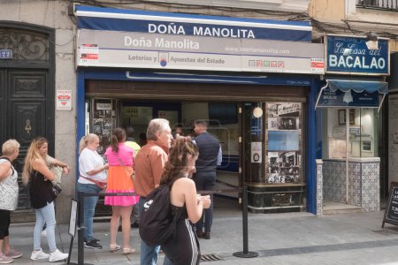 Photo for A long queue outside the Dona Manolita lotto agency office waiting to buy tickets for the Spanish Christmas Lottery, El Gordo, Madrid Spain. - Royalty Free Image