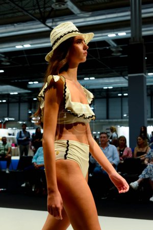 Foto de Una modelo en la pasarela en bikini con volantes amarillos durante la colección de moda Swimdays en la feria Momad 2023 de IFEMA Madrid España. - Imagen libre de derechos