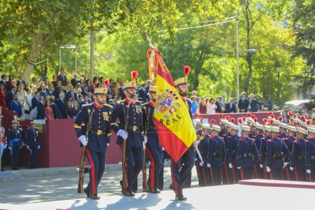 Téléchargez les photos : Garde royale tenant le drapeau espagnol. Quelque 4 100 militaires ont participé au défilé militaire de la fête nationale, dont le roi Felipe VI, la reine Letizia et la princesse Leonor, à Madrid, en Espagne.. - en image libre de droit