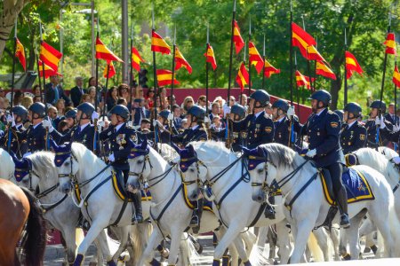 Téléchargez les photos : La cavalerie montée par la police nationale. Quelque 4 100 militaires ont participé au défilé militaire de la fête nationale, dont le roi Felipe VI, la reine Letizia et la princesse Leonor, à Madrid, en Espagne.. - en image libre de droit