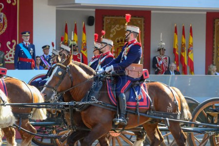 Photo for Horse with mount pulling a cannon carriage passing in front of Filipe VI . Some 4,100 military personnel participated during the National Day military parade including King Felipe VI, Queen Letizia, and Princess Leonor, in Madrid Spain. - Royalty Free Image