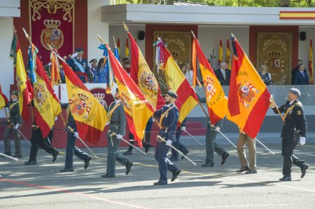 Téléchargez les photos : Des soldats portant le drapeau espagnol du régiment saluant le roi Felipe VI, quelque 4 100 militaires ont participé au défilé militaire de la fête nationale, y compris le roi Felipe VI, la reine Letizia et la princesse Leonor, à Madrid Espagne.i - en image libre de droit