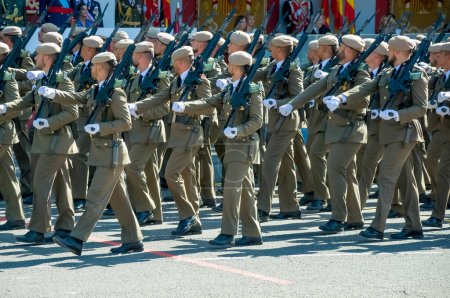 Photo for Marching soldiers in green uniform, some 4,100 military personnel participated during the National Day military parade including King Felipe VI, Queen Letizia, and Princess Leonor, in Madrid Spain.i - Royalty Free Image