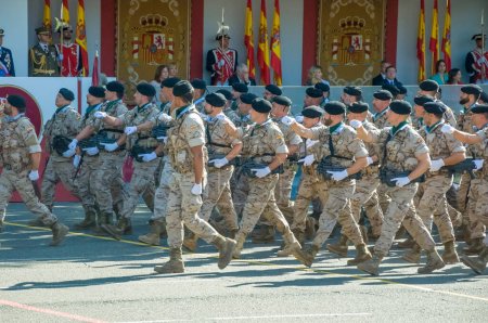 Photo for Marching soldiers in camouflage uniform, some 4,100 military personnel participated during the National Day military parade including King Felipe VI, Queen Letizia, and Princess Leonor, in Madrid Spain.i - Royalty Free Image