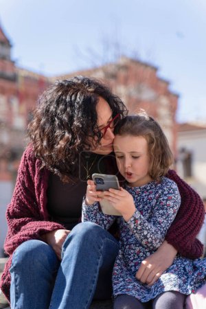 Téléchargez les photos : Mère et fille aiment regarder des photos sur le sparphone - en image libre de droit