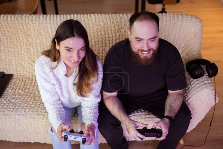 Photo for Young married couple is addicted to virtual games and spends a lot of time together playing video games on consoles. they spend their time playing their favorite games and compete in multiplayer games. favourites. - Royalty Free Image