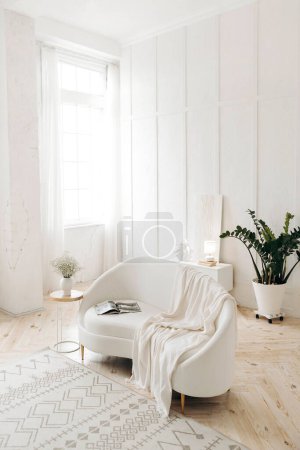 Téléchargez les photos : Salon élégant blanc avec canapé en cuir blanc. Plante en pot à la maison. Grandes fenêtres à l'intérieur. Personne.. - en image libre de droit