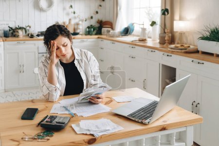 Stressed caucasian woman trying to deal with financial documents, having problem to find money to pay utility bills or loans. The concept of debt, bankrupt. Accounting companies advertisement mockup.
