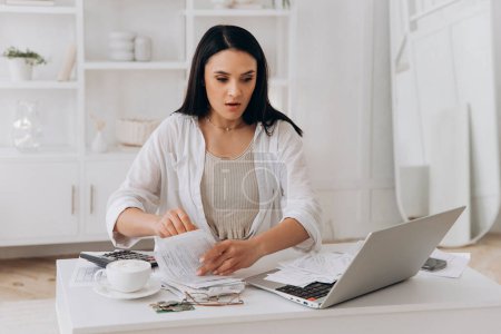 Frightened by tax filing error, young woman pores over financial documents, reflecting real-world challenges in personal finance management, suitable for educational finance platforms.