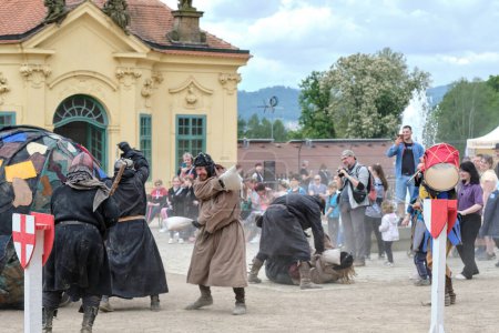 Photo for Decin (Tetschen), Czechia - May 14 2023: Medieval humorous show on town market cultural festival on old castle with fighting monks playing soccer with a huge ball between amused spectators - Royalty Free Image