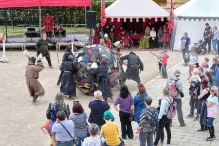 Photo for Decin (Tetschen), Czechia - May 14 2023: Medieval humorous show on town market cultural festival on old castle with fighting monks playing soccer with a huge ball between amused spectators - Royalty Free Image