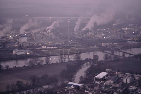 Photo for Lovosice, Czech Republic  Feb 16, 2024: Chemical plant producing fertilizers and polluting environment, industrial smog situation on foggy morning. View over Labe (Elbe). Czechia. Europe. - Royalty Free Image