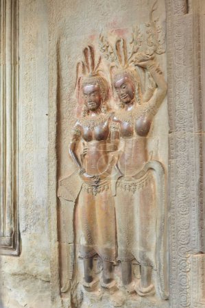 Detaillierte Steinschnitzereien von zwei tanzenden Apsaras an den Wänden des Angkor Wat Tempels in Siem Reap, Kambodscha, die traditionelle Khmer-Kunst präsentieren.