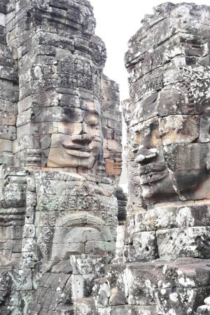 Detaillierte Ansicht der ikonischen geschnitzten Steingesichter im Bayon-Tempel, einem Teil von Angkor Wat in Siem Reap, Kambodscha, die alte Khmer-Architektur und kulturelles Erbe präsentieren.