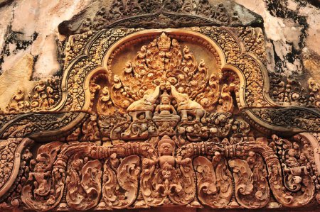 Una talla grande y ornamentada de una persona con un pájaro en la cabeza en Siem Reap Angkor Wat Camboya. La talla está hecha de madera y tiene muchos detalles, incluyendo el pájaro y la cara de la persona.