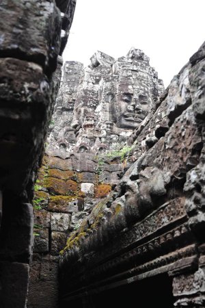 Detailed view of the stone faces at Bayon Temple, part of the Angkor Wat complex in Siem Reap, Cambodia. Historic ruins showcasing intricate carvings.