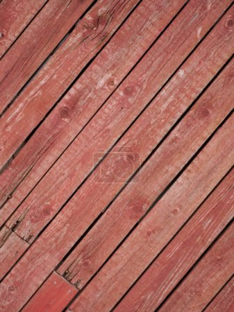 Old rustic board wall painted with red mulch paint on the diagonal. High quality photo