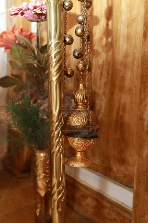 Photo for Close-up with a golden censer in which incense burns and smokes against a bright background. Greek Orthodox Church, preparation of the Orthodox baptism ceremony, interior of the Orthodox Church - Royalty Free Image