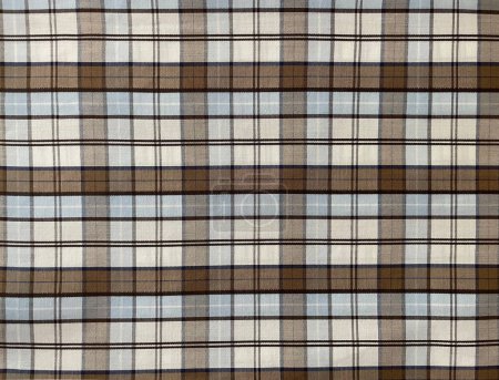 Photo for Plaid fabric closeup. Textured background of crossed white, brown tones and black lines, checks or tartan pattern. Natural linen or cotton towel, cloth, napkin. Textile with grid and squares details. - Royalty Free Image