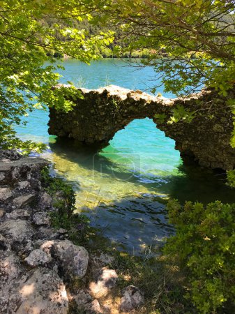 Ruins of a stone wall and green mountain in lake Doxa, in Korinthia Greece.