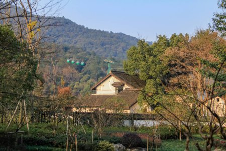 Foto de El paisaje del Lago Oeste en Hangzhou, China con árboles y casas de estilo chino. Viajes y naturaleza. Un parque popular y atracción turística en la ciudad de Hangzhou. - Imagen libre de derechos
