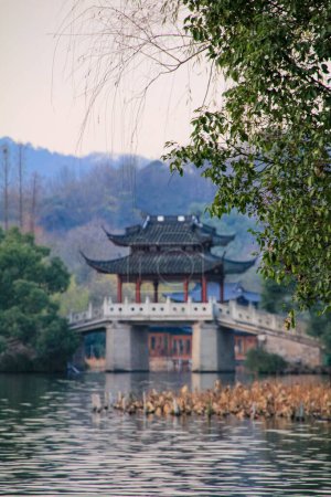 Foto de Famoso puente del pabellón en West Lake, Hangzhou, China. West Lake Jade Belt Bridge con árboles. Viajes y naturaleza. Parque popular de la ciudad de Hangzhou China. - Imagen libre de derechos